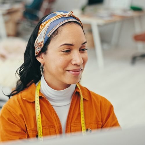 Happy, woman and fashion designer on tablet at office for online orders, delivery and supply chain.